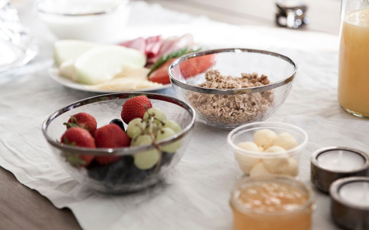 Breakfast table with fresh fruit, granola and juice