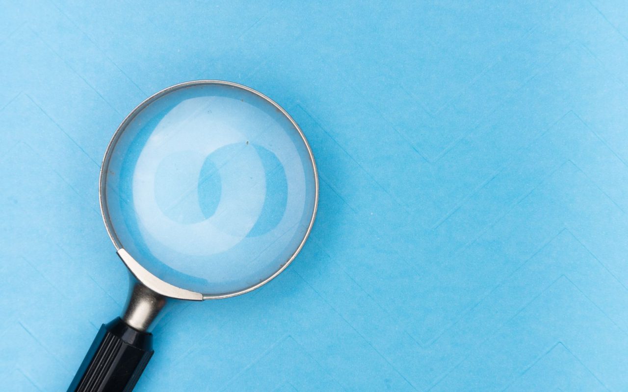 A magnifying glass on a blue surface