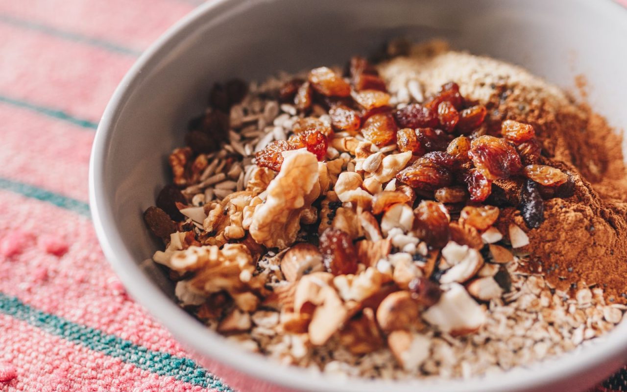 A bowl of oatmeal topped with walnuts and seeds